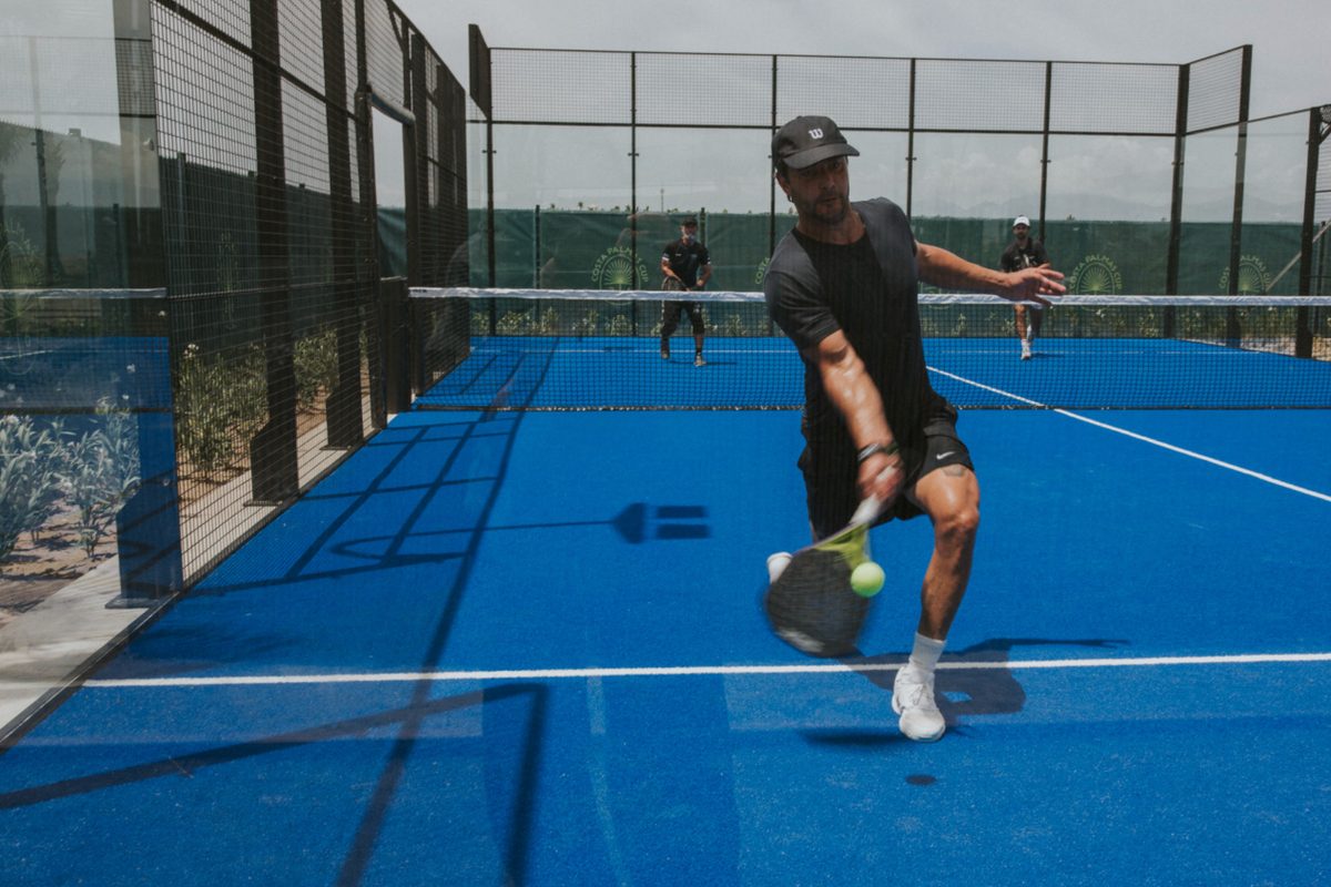 A player stretching for a low forehand on the courts at Costa Palmas